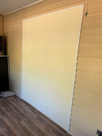 A large flush panel framed in white trim is set into a wood-paneled wall above LVP flooring.