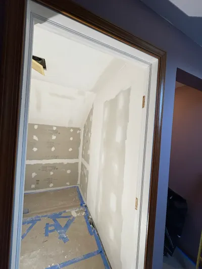 Small bathroom under renovation with taped drywall, cement backer board, sloped ceiling and papered floor
