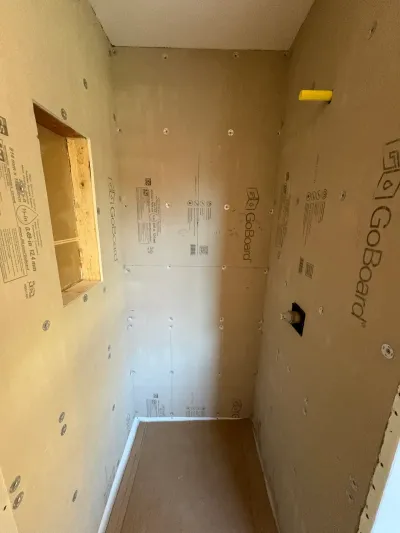 Walk-in shower alcove framed and sheathed in GoBoard backer board with a recessed niche and valve rough-in.